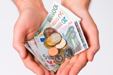 Symbolbild: Zwei Hände sind geöffnet und zu einer Schale geformt. Darin liegen Geldscheine und Münzen. Foto: ccvision