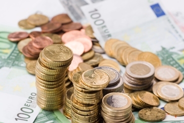 Symbolbild: Mehrere Stapel und lose Münzen liegen auf Geldscheinen. Foto: ccvision