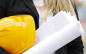 Eine Frau hält einen Bauplan in der Hand und trägt einen Bauhelm unter dem Arm. Foto: Wellnhofer-Designs-Fotolia