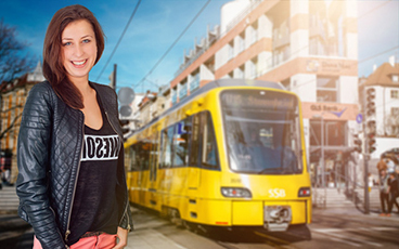 Eine junge Frau vor einer Stadtbahn.