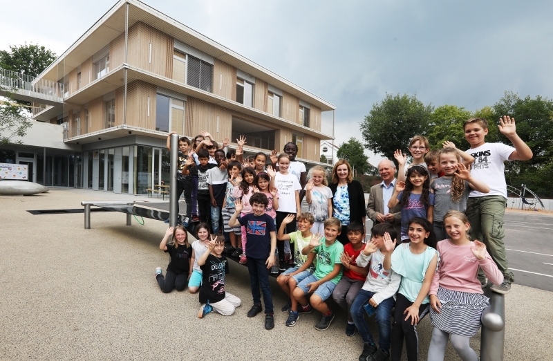 Bürgermeisterin Isabel Fezer (m.l.) und Rektor Reinhold Sterra (m.r.) mit Schülern der Kirchhaldenschule bei der Einweihung des Kinderhauses. Foto: Thomas Hörner