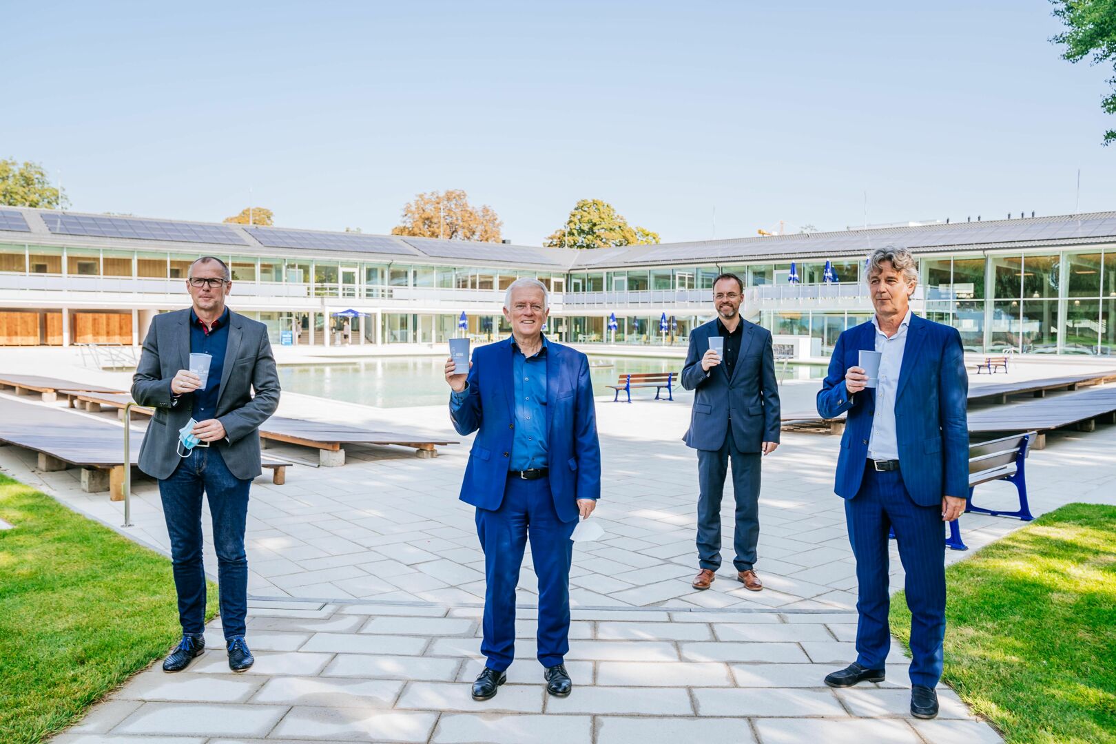 Technik-Bürgermeister Dirk Thürnau, Oberbürgermeister Fritz Kuhn, Bäderchef Alexander Albrand und Architekt Matthias Burkart (von links) heben ein Glas auf das neu sanierte Mineralbad Berg – natürlich mit quellfrischem Mineralwasser aus den neuen Trinkbrunnen. Foto: Thomas Niedermüller, Rechte: LHS.