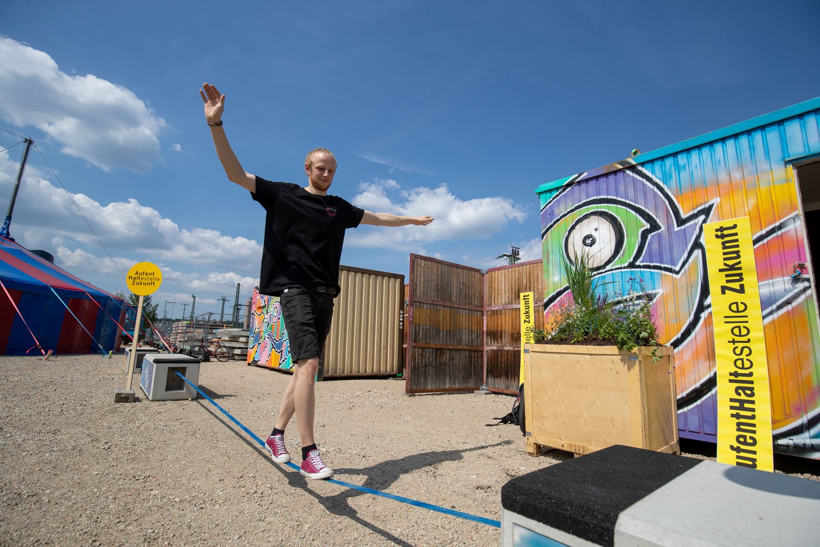 Ein junger Mann balanciert auf einer Slackline.