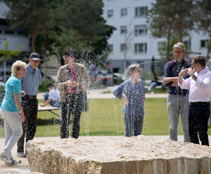 Interessierte Bürgerinnen und Bürger vor der neuen Brunnenanlage im Quartierspark.