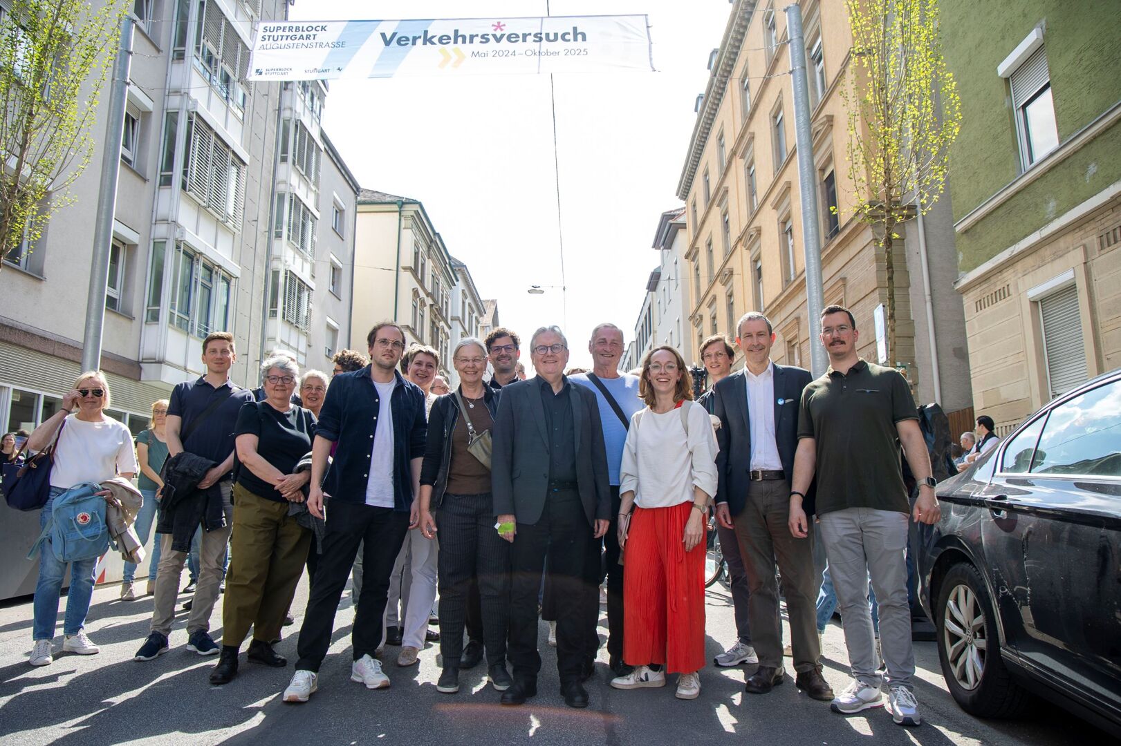 Eine Gruppe von Menschen steht auf der Straße im Superblock.