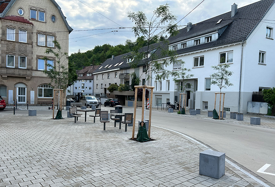 Das Bild zeigt einen der neu gestalteten Kreuzungsbereiche in Gablenberg mit Sitzgelegenheiten und neu gepflanzten Bäumen.